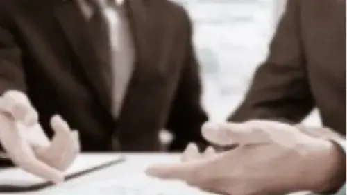 Two people in suits showing only their hands and a document
