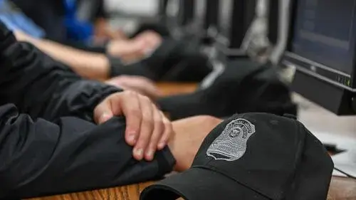 Agent at computer with law enforcement hat on desk