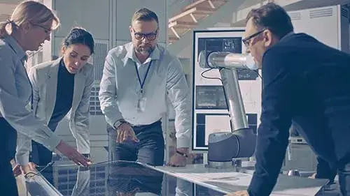group of people looking over papers on desk