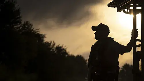 Image of a US Border Patrol agent on a boat at sunset.